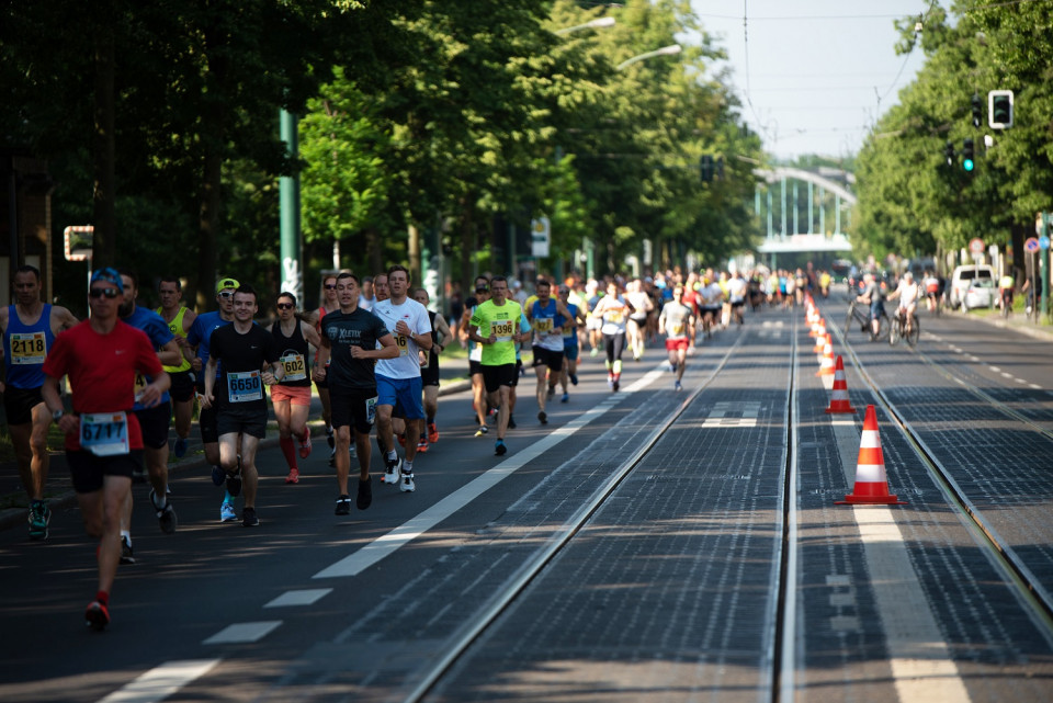 Schlösserlauf 2019: auf der linken Seite laufen die Teilnehmer, die Kombispur für Straßenbahn und Bus ist in beiden Fahrtrichtungen gesperrt.