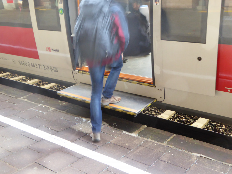 Eine Person steigt in einen Regionalzug. Der Abstand zwischen Bahnsteig und Zugeinstieg beträgt etwa 50 cm. Am Zug ist eine Treppenstufe auf der Höhe von etwa 25 cm ausgefahren. Foto: DBV-Archiv