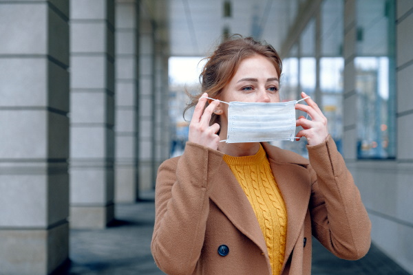 Eine Frau nimmt ihre Maske ab. Foto: pexels, anna