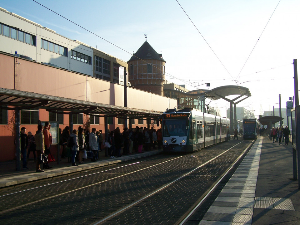 Die Straßenbahn-Haltestelle Potsdam Hauptbahnhof mit einem einfahrenden Combina-Zug der Linie 93. Auf dem Bahnsteig warten viele Fahrgäste.