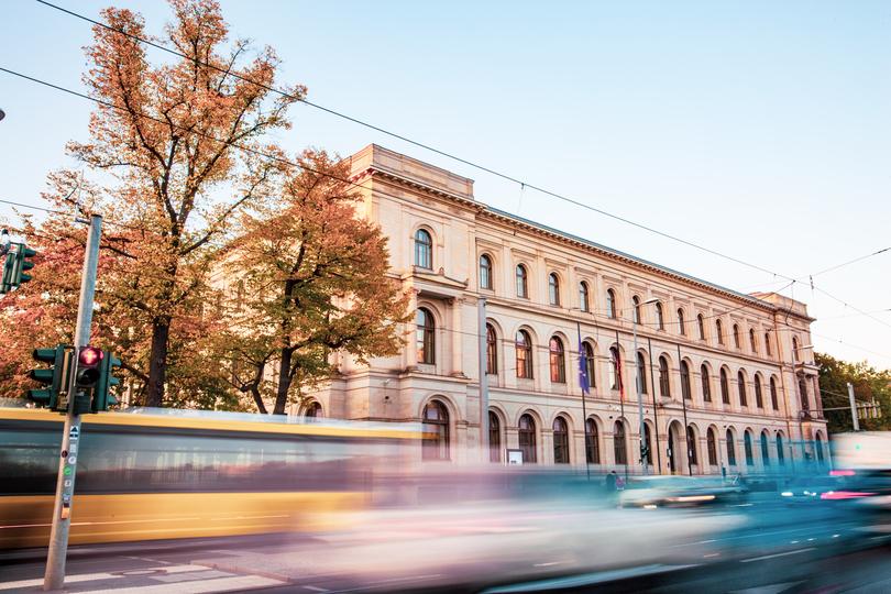 Der Berliner Dienstsitz des Bundesverkehrsministeriums für Digitales und Verkehr mit vielen Fenstern an einer belebten Straße bei Sonnenuntergang