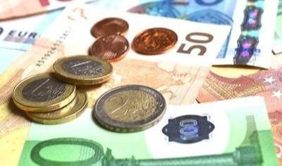 Verschiedene Euro-Banknoten und Münzen in unterschiedlichen Werten liegen auf einem Tisch 