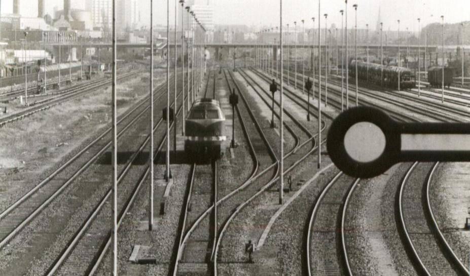 Blick auf den Güterbahnhof Moabit in Berlin um 1988 mit mehreren Gleisen, einer abgestellten Lokomotive und zahlreichen Laternenpfählen