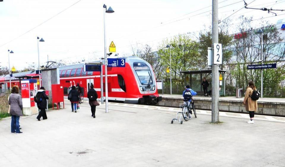 Regionalexpress steht am Bahnsteig 3 des Bahnhofs Berlin-Lichterfelde Ost, mehrere wartende Personen sichtbar.